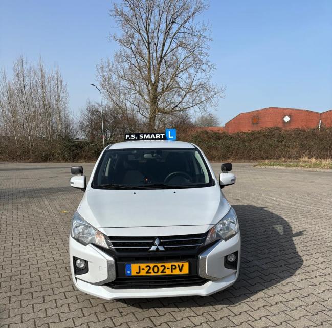 Lesauto van F.S. Smart vooraanzicht met kenteken J-202-PV en F.S. Smart daklicht.