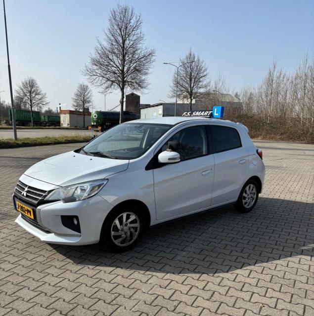 Witte Mitsubishi Space Star lesauto van F.S. Smart met daklicht.